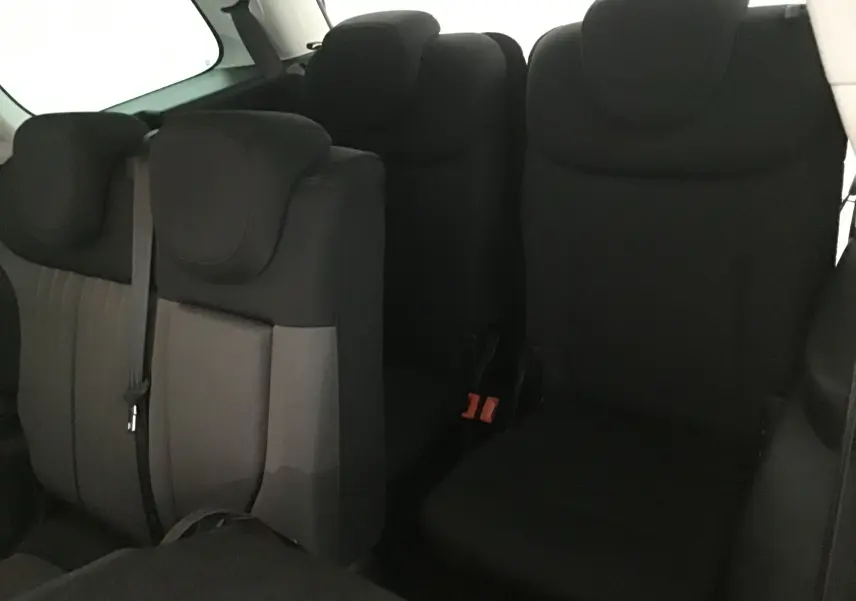 Vue intérieure montrant les sièges arrière noirs du Fiat 500L 7 places, avec appuie-têtes et ceinture visible.