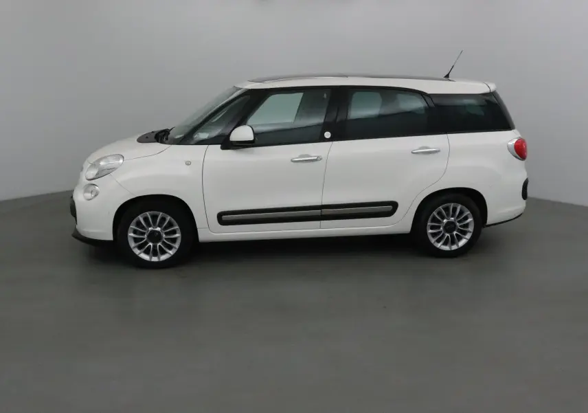 Profil côté gauche d'une FIAT 500L blanche de 2015 avec lunette arrière surteintée dans un studio neutre.