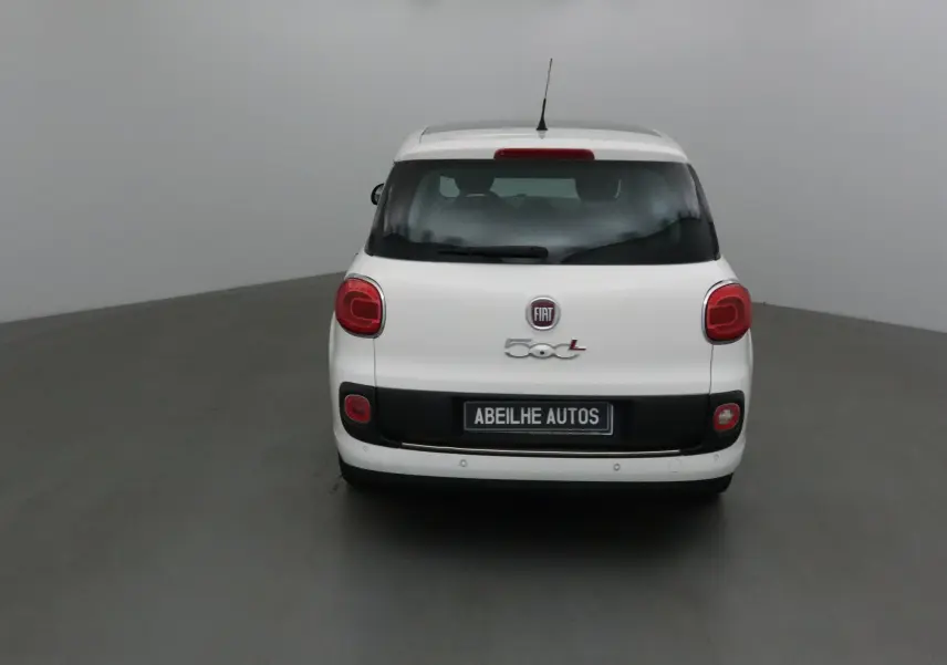Vue arrière d'une Fiat 500L blanche de 2015 avec lunette arrière surteintée et feux rouges arrondis.
