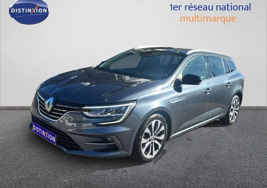 Renault Mégane Break gris titanium métal en 3/4 avant droit, jantes alliage et calandre moderne visible.