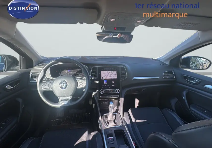 Vue intérieure avant de la Renault Mégane Break 2024 gris titanium, avec tableau de bord numérique et écran tactile central.