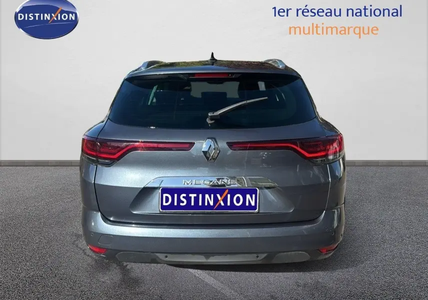 Vue arrière d'une Renault Mégane Break gris titanium métal, avec feux LED et logo distinctif au centre.