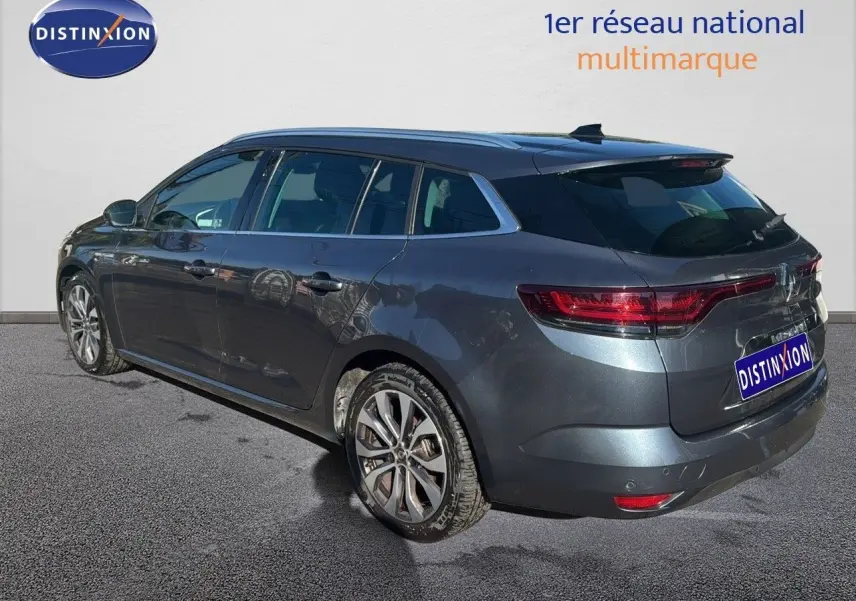 Renault Mégane Break gris titanium métal vue 3/4 arrière droit, feux LED et jantes alliage visibles.