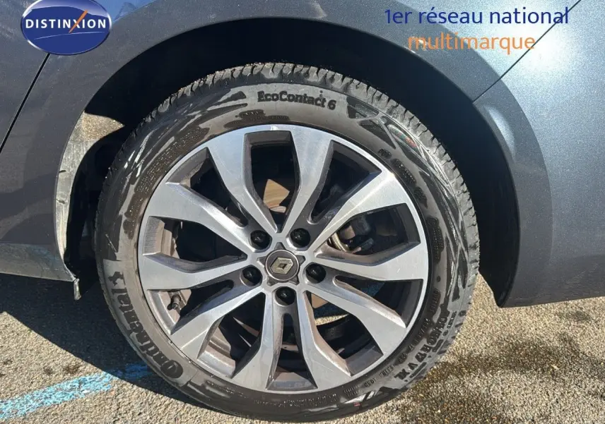 Gros plan sur la roue avant droite d'une Renault Mégane Break gris titanium avec jante alliage à dix branches.