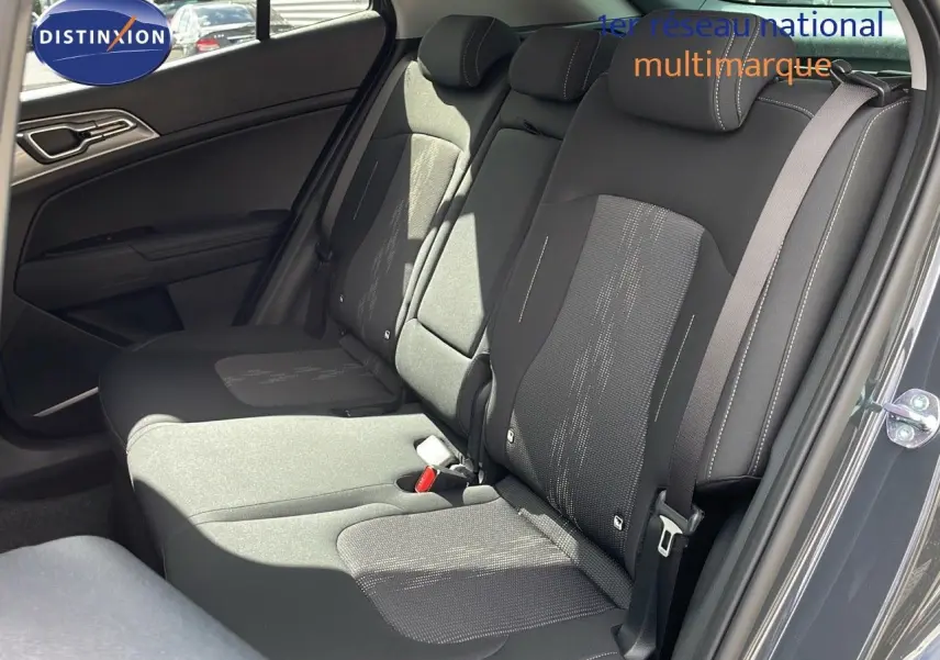 Vue intérieure côté droit des sièges arrière en tissu noir du Kia Sportage gris foncé 2025, avec ceinture de sécurité visible.