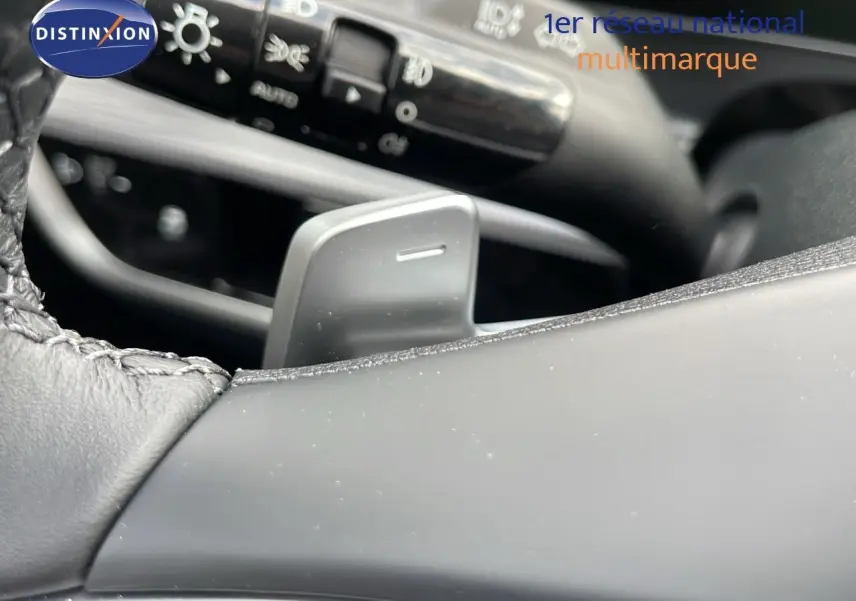 Gros plan sur la palette de changement de vitesse côté droit du volant cuir du Kia Sportage gris foncé 2025.