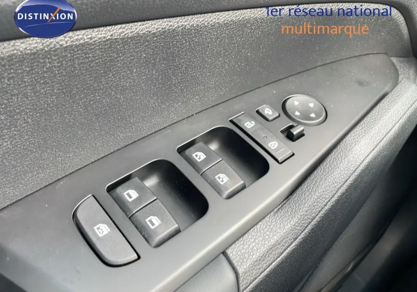 Gros plan sur les commandes des vitres et rétroviseurs côté gauche d'un Kia Sportage gris foncé 2025.