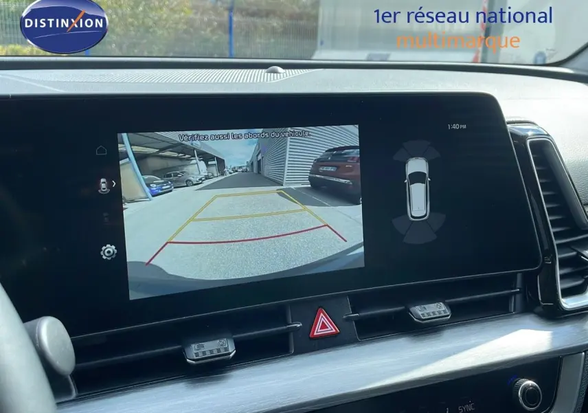 Écran tactile intérieur du Kia Sportage 2025 montrant la caméra de recul avec vue arrière et alertes de stationnement.