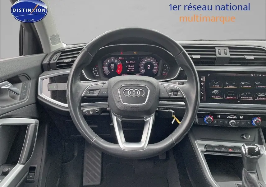 Vue intérieure centrée sur le volant Audi Q3 35 TFSI 2019 avec tableau de bord numérique et console moderne.