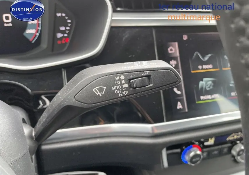 Gros plan sur la commande d’essuie-glace du tableau de bord d’un Audi Q3 35 TFSI gris, avec écran tactile en arrière-plan.