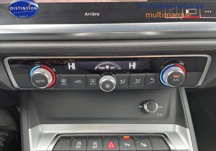 Console centrale de l'Audi Q3 35 TFSI 2019 montrant les commandes de climatisation automatique et les boutons de sécurité.