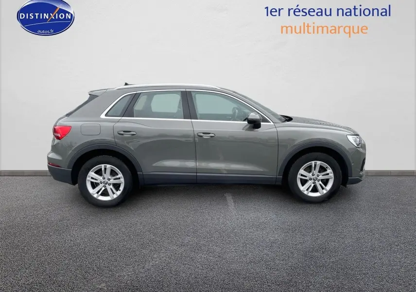 Audi Q3 gris chronos métal vu de profil côté gauche, avec jantes alliage et lignes épurées.