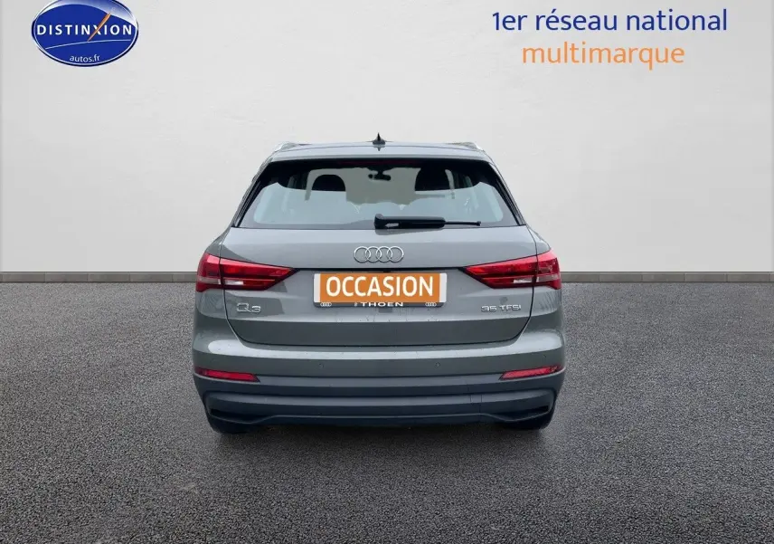 Vue arrière d'un Audi Q3 gris Chronos métal de 2019 avec plaques d'occasion et feux arrière allumés.