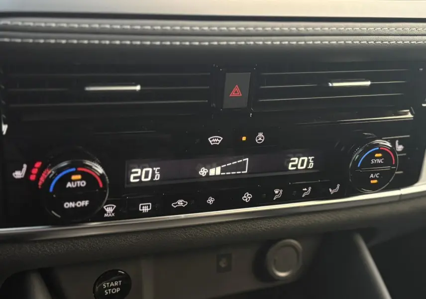 Gros plan sur la console centrale du Nissan Qashqai III gris Ceramic, affichant la climatisation automatique bi-zone à 20°C.