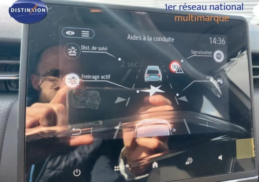 Écran tactile intérieur de la Renault Clio blanc 2021 affichant les aides à la conduite et la détection des panneaux.