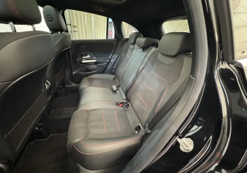 Vue intérieure côté droit des sièges arrière noirs avec surpiqûres rouges d’un Mercedes GLA 250 e AMG Line 2021.