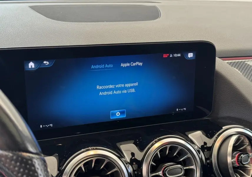 Vue intérieure du tableau de bord noir d'une Mercedes GLA 250 e AMG Line 2021 avec écran tactile central allumé.