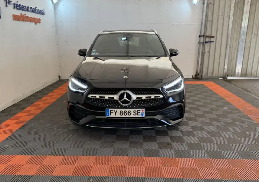 Vue avant d’un Mercedes GLA 250 e AMG Line noir avec phares LED allumés, calandre étoilée et plaque d’immatriculation française.