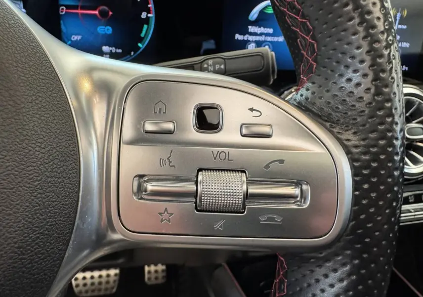 Gros plan sur les commandes multifonctions en métal et cuir perforé du volant du Mercedes GLA 250 e AMG Line noir, 2021.