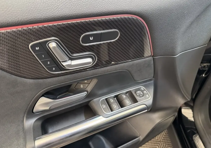 Détail de la porte côté conducteur d’un Mercedes GLA 250 e AMG Line noir avec commandes sièges et vitres.