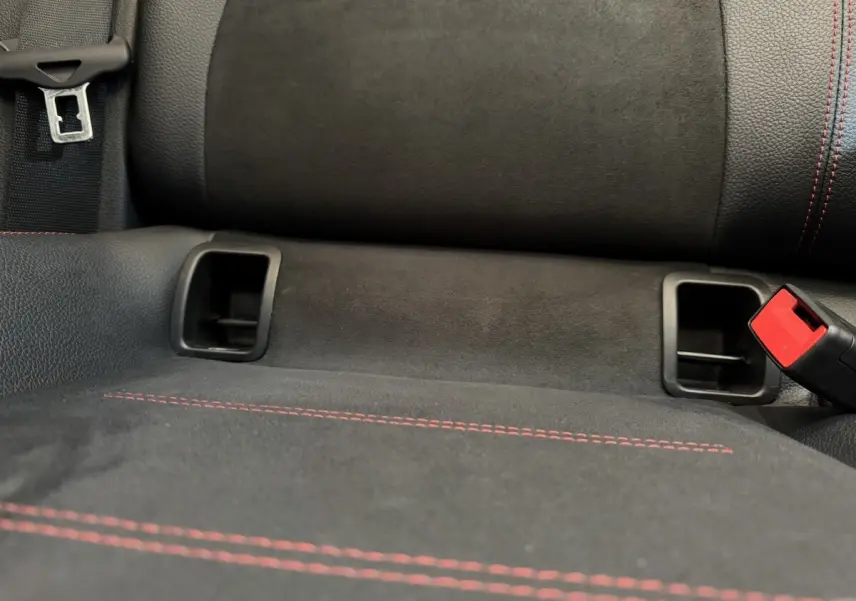 Gros plan sur la banquette arrière noire avec surpiqûres rouges et ceintures de sécurité du Mercedes GLA 250 e AMG LINE.