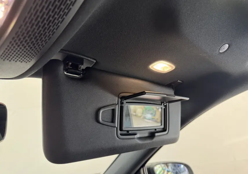 Détail intérieur du pare-soleil côté conducteur avec miroir éclairé dans un Mercedes GLA noir 2021.