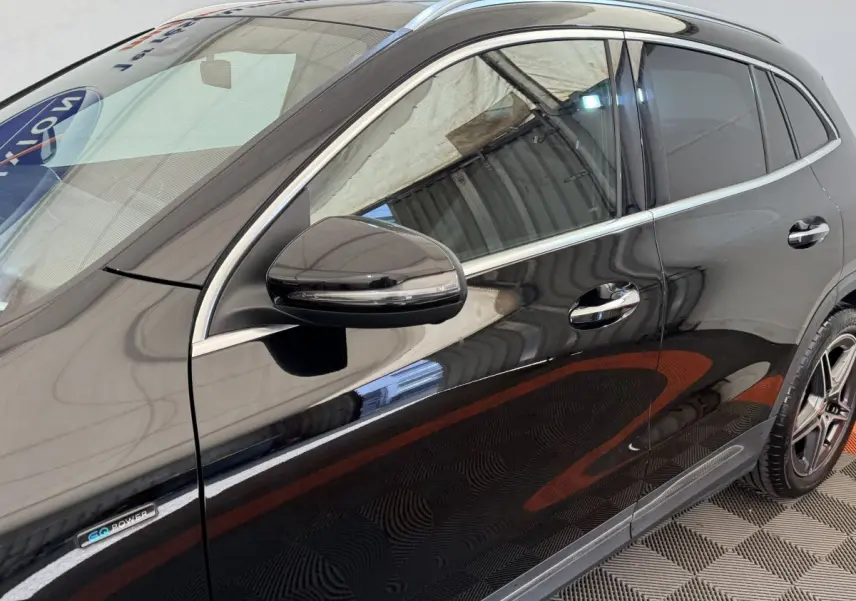 Vue côté gauche du Mercedes GLA 250 e AMG Line noir avec rétroviseur et badge EQ Power visibles.