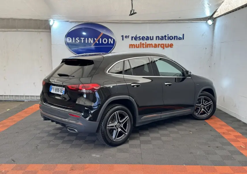 Vue 3/4 arrière droite d'un Mercedes GLA 250 e AMG Line noir brillant, avec jantes alliage et feux LED distinctifs.
