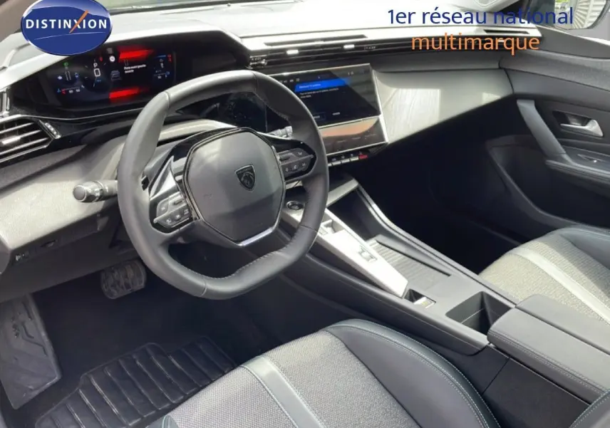 Vue intérieure côté conducteur du Peugeot 308 SW Hybrid 2025, volant cuir noir et tableau de bord digital moderne.