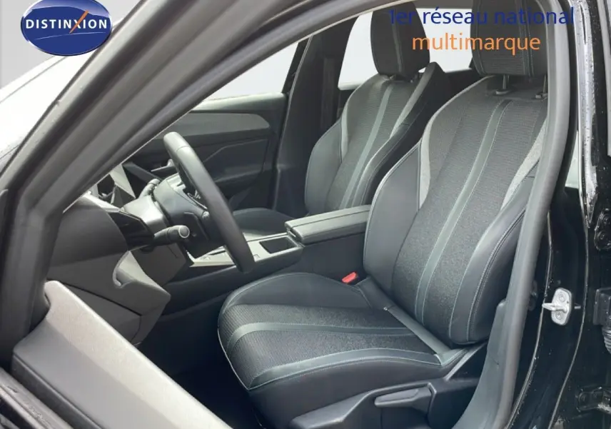 Vue intérieure côté conducteur du Peugeot 308 SW Hybrid 145ch Allure 2025 noir métal, sièges tissu et cuir gris noir.