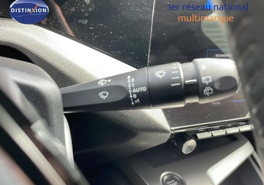Gros plan sur la commande d'essuie-glace à gauche du volant dans l'habitacle d'une Peugeot 308 SW noir métal 2025.