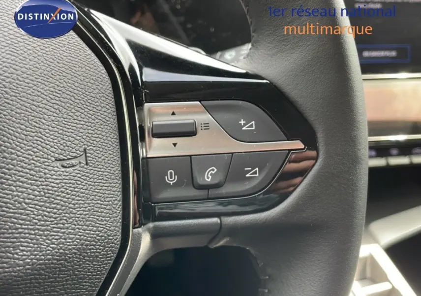 Gros plan sur les commandes du volant noir de la Peugeot 308 SW Hybrid 145ch Allure, intérieur gris noir.