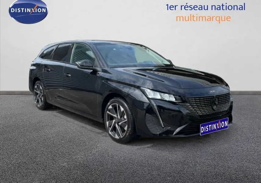 Peugeot 308 SW noir métal en 3/4 avant droit, break hybride avec jantes alliage distinctives.