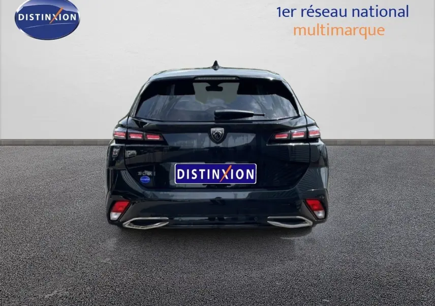 Vue arrière d'une Peugeot 308 SW Hybrid noire métal 2025 avec feux LED et double sortie d'échappement intégrée.