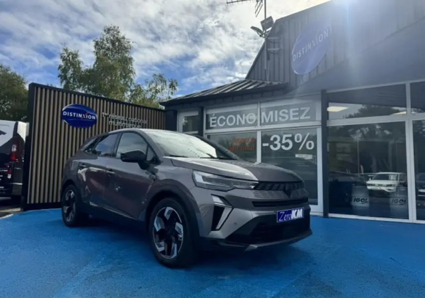 Renault Symbioz 1.8 E-Tech gris Cassiopée métallisé en 3/4 avant droit, avec jantes alu et calandre noire distinctive.