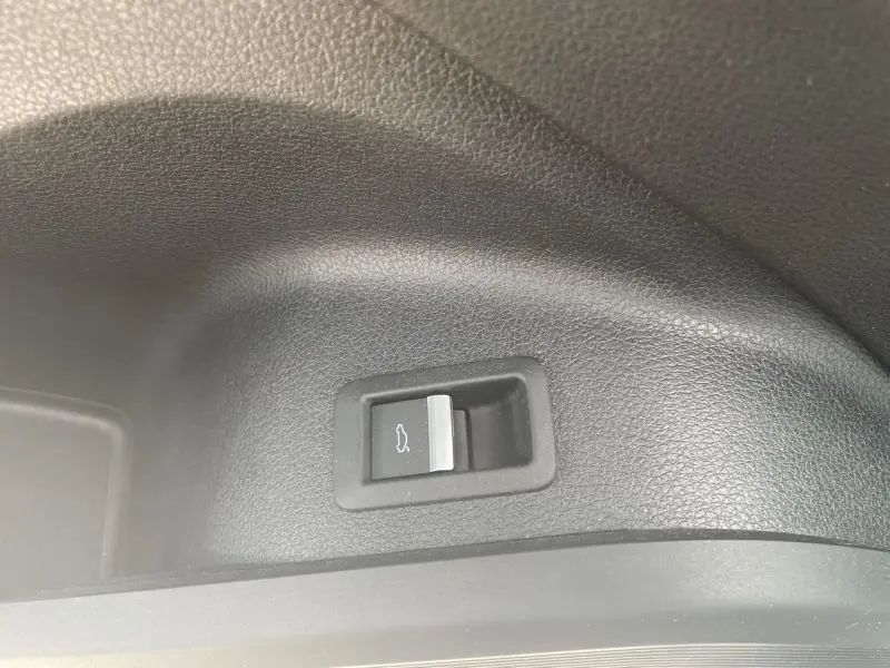 Bouton d'ouverture du coffre en plastique noir texturé à l'intérieur d'un Audi Q5 2.0 TFSI 252 AVUS noir métal de 2017.