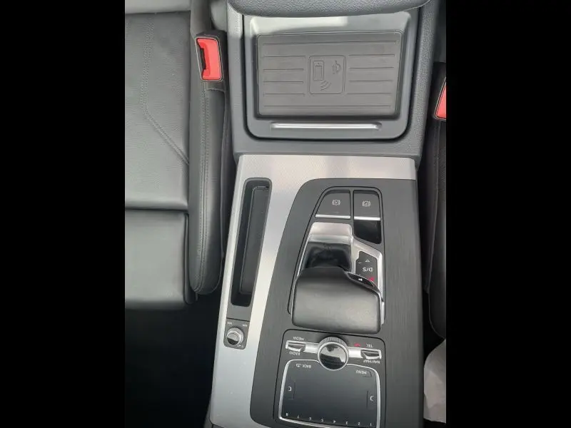 Gros plan sur la console centrale de l'Audi Q5 2017 noir métal, montrant le levier de vitesse automatique et les commandes tactiles.