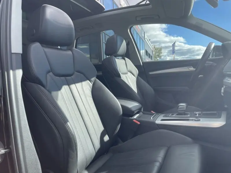 Intérieur de l'Audi Q5 2017 noir métal, vue côté gauche sur les sièges avant en cuir et le toit ouvrant panoramique.