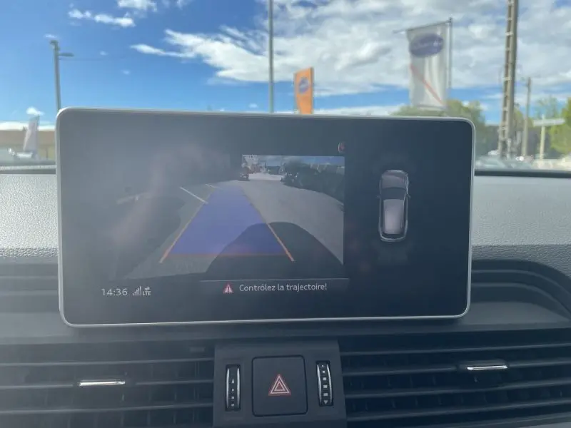 Écran central de l'Audi Q5 2017 noir métal montrant la caméra de recul avec guidage de trajectoire en extérieur lumineux.