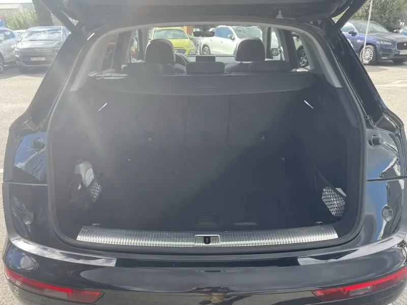 Coffre ouvert vu de l'arrière d'un Audi Q5 noir métal 2017, montrant un espace de chargement spacieux et propre.
