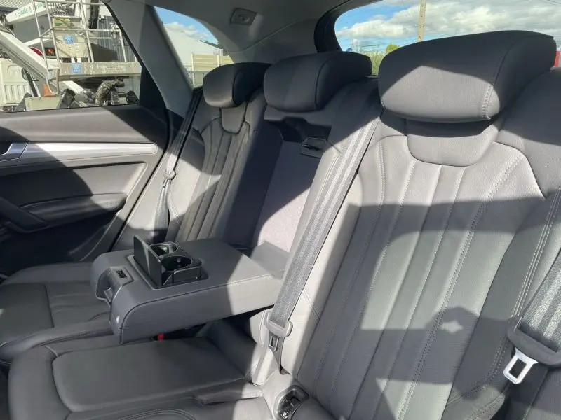 Vue intérieure arrière de l'Audi Q5 2017 noir métal, montrant les sièges en cuir gris avec accoudoir central déplié.
