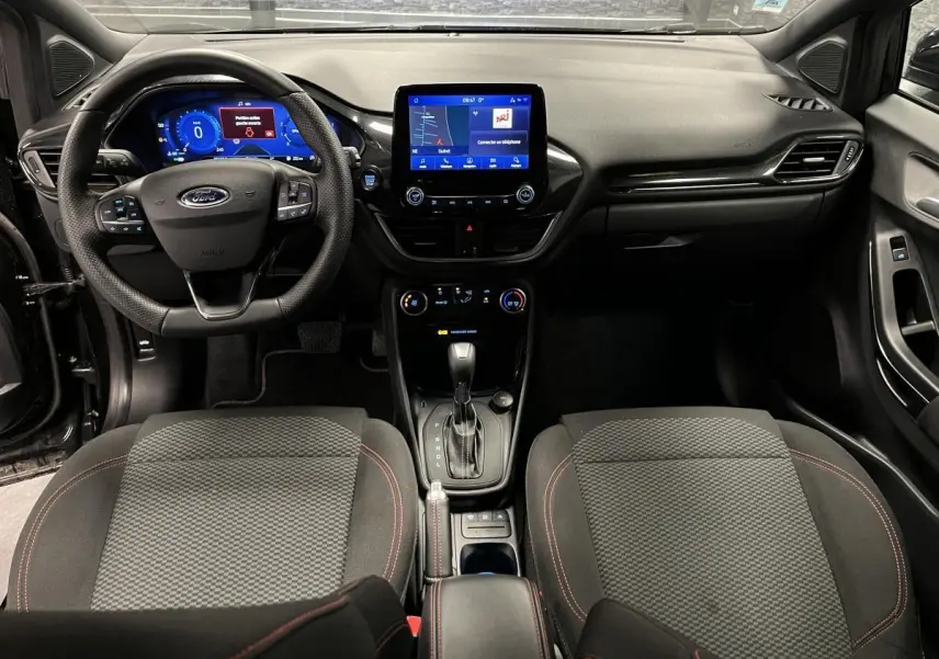 Vue intérieure avant du Ford Puma 2023 noir avec tableau de bord numérique et console centrale moderne.