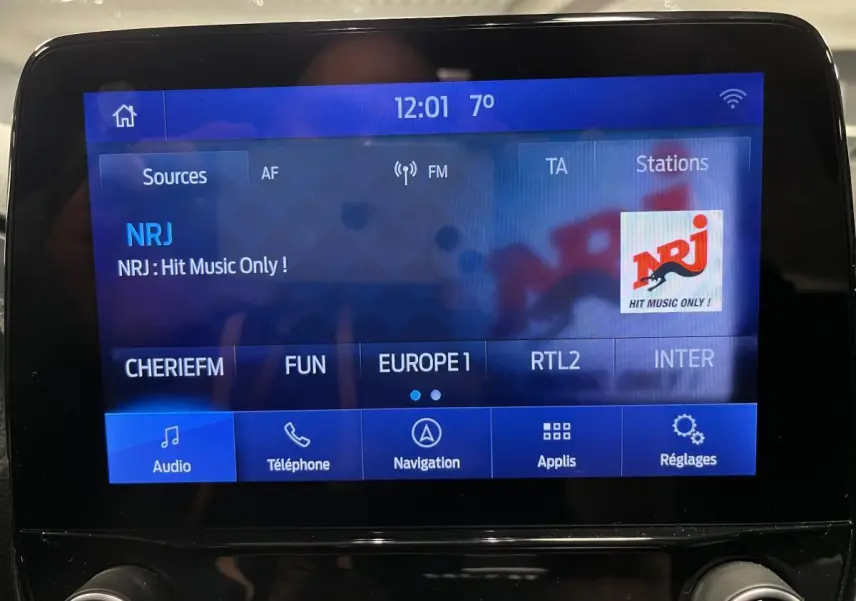 Écran tactile central du Ford Puma 2023 affichant la radio NRJ avec interface bleue et commandes audio visibles.