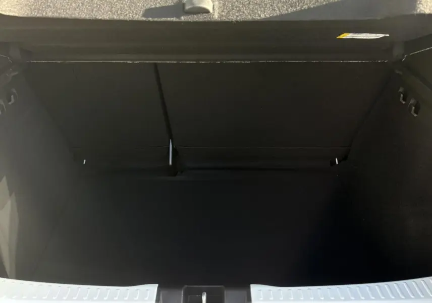 Coffre ouvert noir spacieux du Dacia Sandero Stepway 2024, vue intérieure arrière sans chargement visible.