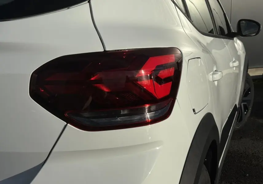 Feu arrière droit en gros plan sur Dacia Sandero Stepway blanc glacier, vue latérale arrière droite.