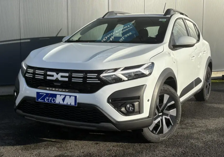 Vue 3/4 avant droite d'une Dacia Sandero Stepway blanche Glacier avec signature lumineuse LED et jantes noires distinctives.