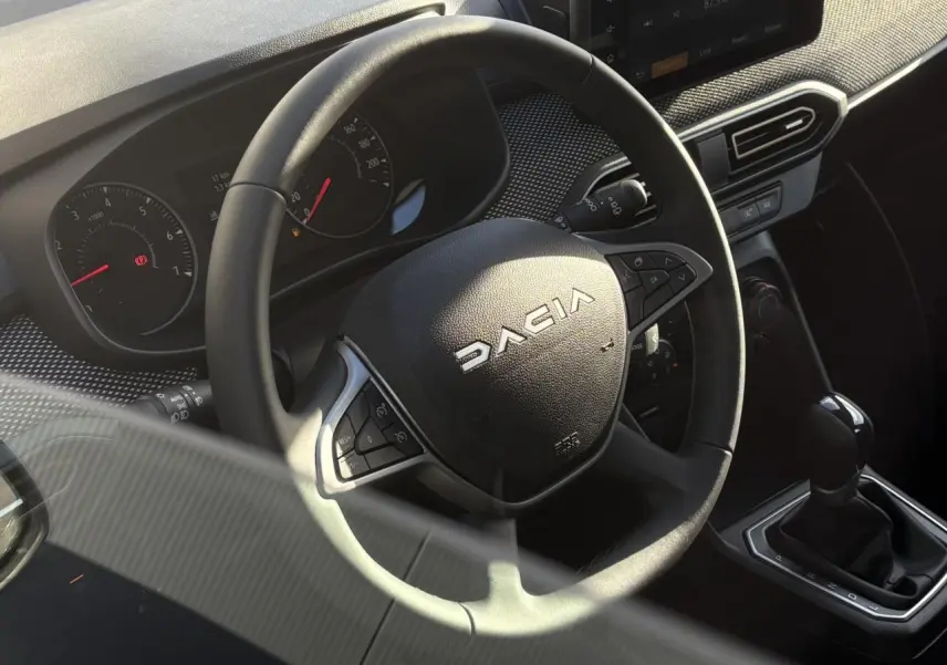Vue rapprochée du volant Dacia et de la console centrale avec levier de vitesse de la Sandero Stepway 2024.