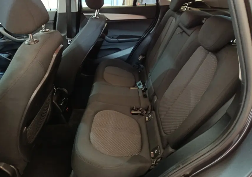 Vue intérieure côté droit des sièges arrière noirs du BMW X1 sDrive18i Lounge DKG7 gris foncé de 2021.