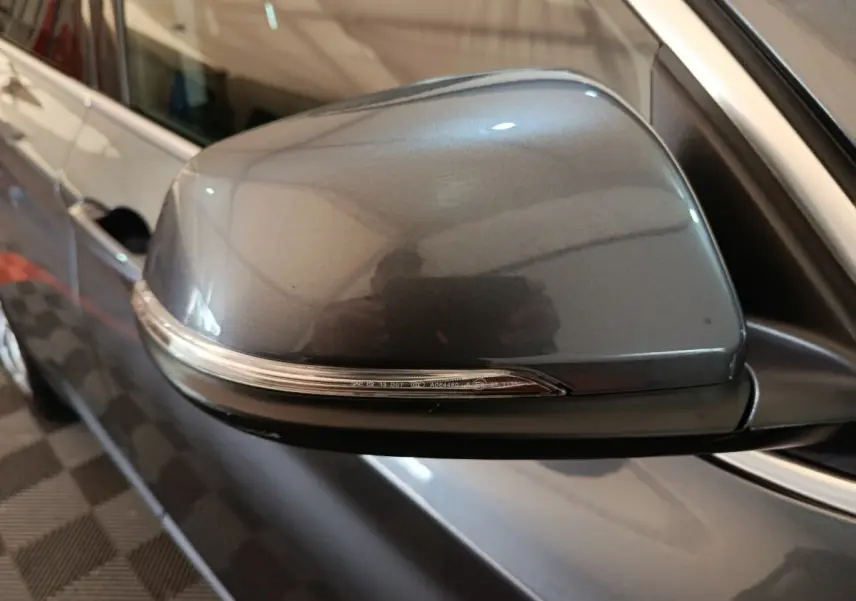 Gros plan sur le rétroviseur côté gauche gris foncé du BMW X1 sDrive18i Lounge 2021 avec clignotant intégré.