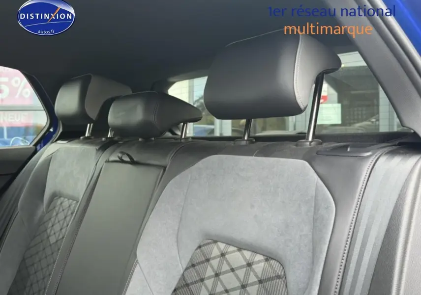 Vue intérieure sur la banquette arrière en tissu gris avec appuie-têtes noirs d’une Volkswagen Golf bleue 2024.